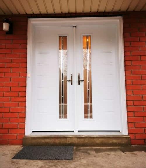 White double doors with brick wall