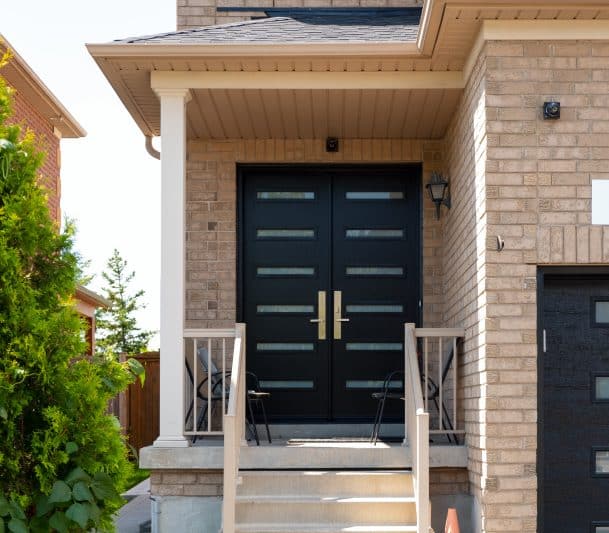 Front porch with black double doors.
