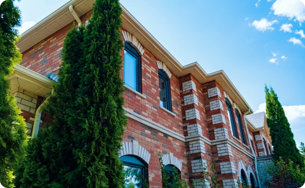 Red brick house with tall trees